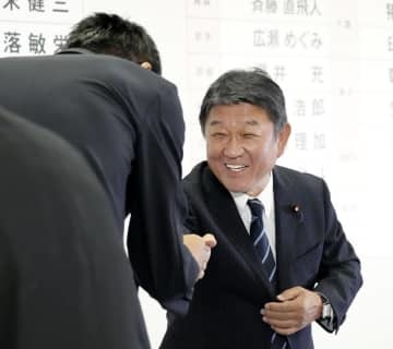 当選を確実にした候補者とタッチする自民党の茂木幹事長＝10日午後9時33分、東京・永田町の党本部