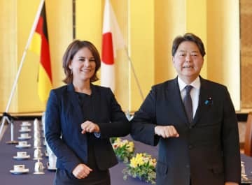 会談前、撮影に応じる林外相（右）とドイツのベーアボック外相＝11日午前、東京都港区（代表撮影）