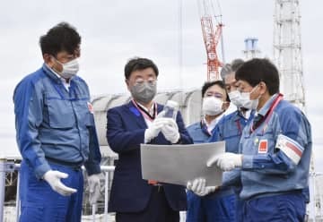 東京電力福島第1原発を視察し、説明を受ける松野官房長官（左から2人目）＝16日午前（代表撮影）