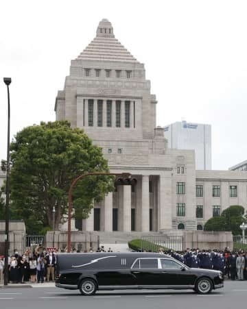 国会前を通過する安倍元首相のひつぎを乗せた車＝12日