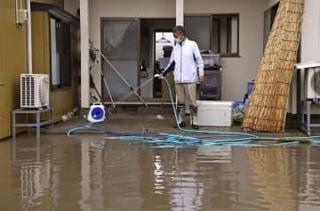 大雨の影響で浸水した自宅の掃除をする男性。家屋は床上1メートルまで水に漬かり、冷蔵庫やテレビなどの家電製品が壊れたという。「この7年で3回目の被害。堤防をしっかりと整備してほしい」と訴えた＝17日午前、宮城県大崎市
