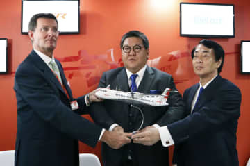 欧州の航空機メーカー関係者らと写真に納まる鳥取ガスの児嶋太一社長（中央）＝18日、英南部ファンボロー（鳥取ガス提供）
