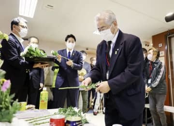 船内の献花台に花を供える色丹島出身の得能宏さん＝23日午前、北海道根室半島沖の洋上