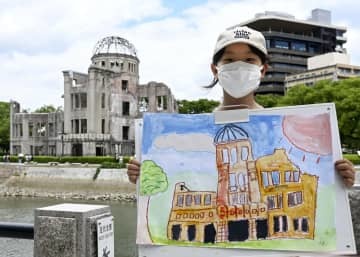 原爆ドームの絵を描いた栗原莉奈さん＝23日午後、広島市の平和記念公園