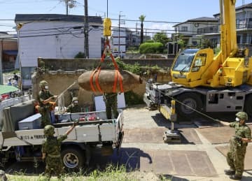 信管が取り除かれた不発弾をトラックに積み込む陸上自衛隊員ら＝24日午後、大阪府吹田市