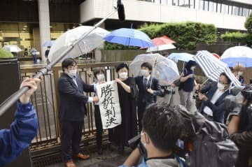 「1型糖尿病」訴訟の判決後、「勝訴判決」の紙を掲げる原告ら＝26日午前、東京地裁