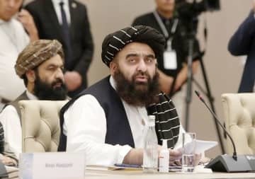 26日、ウズベキスタンの首都タシケントで行われた国際会議で演説するアフガニスタンのムッタキ外相（共同）