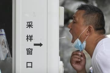 北京で新型コロナの検査を受ける男性＝19日（AP＝共同）