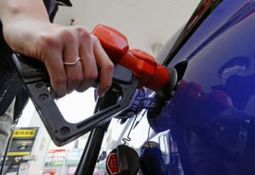 東京都内のガソリンスタンドで給油する人＝3月