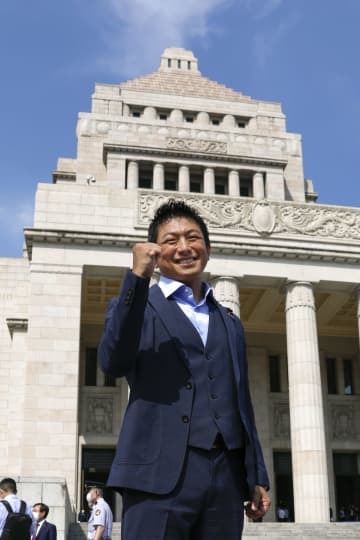 国会に初登院しポーズをとる参政党の神谷宗幣参院議員＝3日午前8時55分