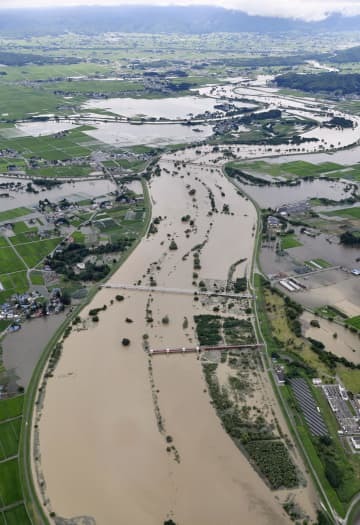 大雨の影響で増水した、山形県の南陽市（右側）と川西町を流れる最上川＝4日午後2時10分（共同通信社機から）