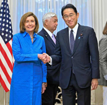 朝食会を前にペロシ米下院議長（左）と握手をする岸田首相＝5日午前、首相公邸（代表撮影）