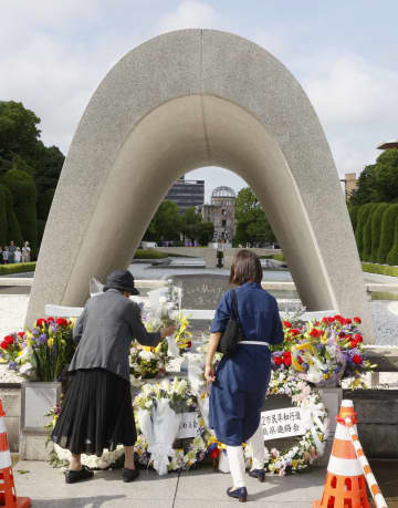 被爆から77年の「原爆の日」を前に、広島市の平和記念公園を訪れ、慰霊碑に献花する人たち＝5日午後