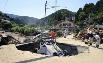 道路の陥没部分から引き上げられる車＝8日、福井県南越前町