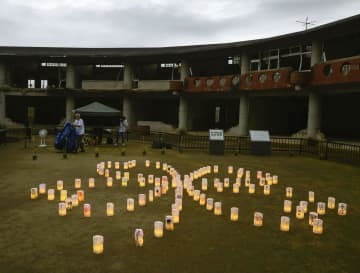 児童や教職員84人が亡くなった宮城県石巻市立大川小の中庭で、四つ葉のクローバーの形に設置された108個の紙灯籠＝14日夕、宮城県石巻市