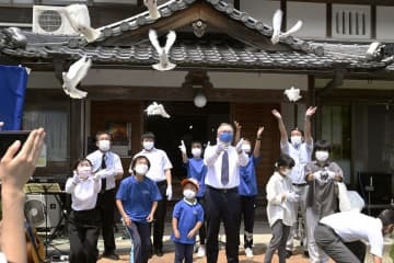 米兵と地元戦没者の慰霊祭で、鳩を飛ばす参列者＝15日正午ごろ、三重県名張市