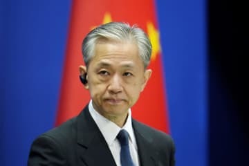 記者会見する中国外務省の汪文斌副報道局長＝18日、北京（共同）
