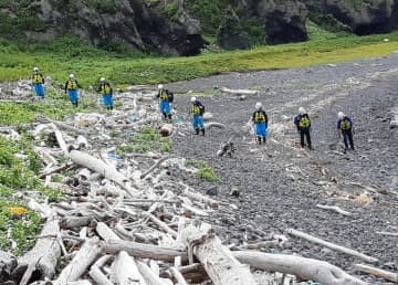 知床半島の海岸で行方不明者を捜索する警察官ら＝18日午後、北海道斜里町（北海道警提供）