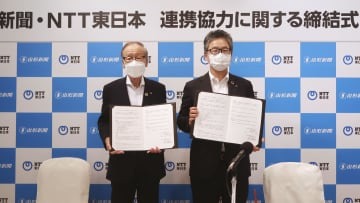 連携協定書を手にする山形新聞社の寒河江浩二社長（左）とNTT東日本の渡会俊輔山形支店長＝19日午後、山形市