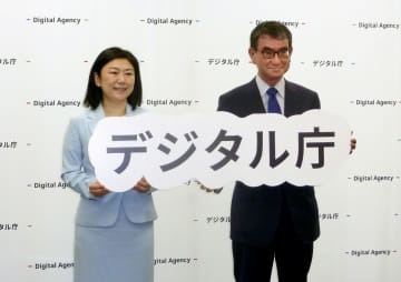 17日、デジタル庁での就任式で記念撮影に応じる河野デジタル相（右）と牧島前デジタル相