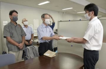 広島県の担当者に住民監査請求書を手渡す山田延広弁護士（左）ら＝5日午後、広島県庁