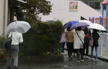 川崎幼稚園が開いた説明会に向かう保護者ら＝7日午前、静岡県牧之原市