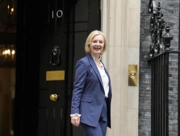 英議会に向かうため首相官邸を出るトラス首相＝7日（AP＝共同）
