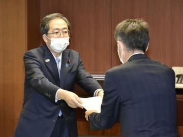 日野自動車の小木曽聡社長（右）に是正命令書を手渡す斉藤国交相＝9日午後、国交省
