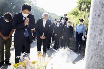 事故現場近くの慰霊碑で献花し黙とうする遺族ら＝10日午後、長野県軽井沢町