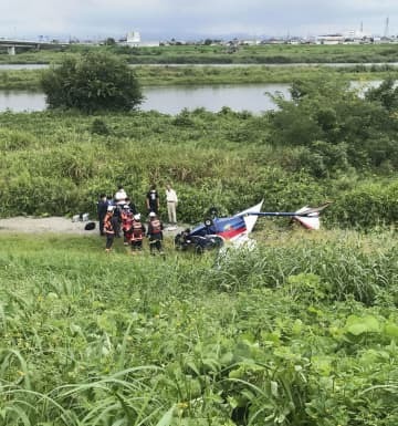 墜落した超軽量飛行機を調べる警察官ら＝10日午前10時49分、群馬県玉村町