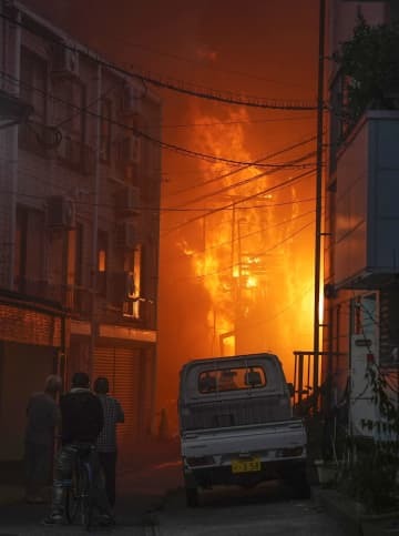 炎が上がる、木造2階建てが全焼した火災現場＝16日午後6時35分、福岡市中央区
