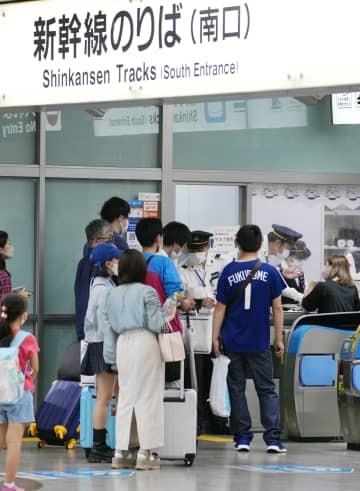 降雨のため東海道新幹線の運転が中止となり、対応に追われる駅員ら＝23日午後11時43分、JR名古屋駅