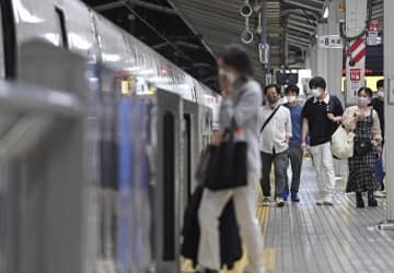 「列車ホテル」として開放された新幹線の車両に乗り込む人たち＝24日午前0時40分、JR東京駅