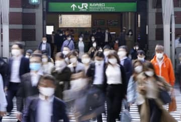 マスク姿で通勤する人たち＝JR東京駅前