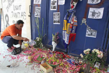 4日、インドネシア・マランのサッカー場で、出入り口に花びらをまき犠牲者を悼む男性（Antara　Foto/Ari　Bowo　Sucipto提供、ロイター＝共同）