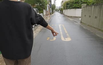 男性米兵に突き飛ばされ、重傷を負った現場付近を指さす被害に遭った女性＝10月、神奈川県逗子市