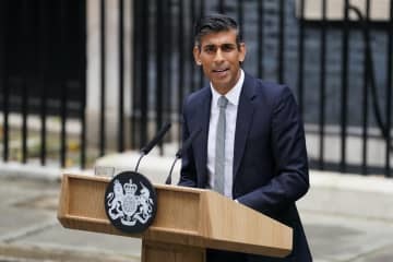 25日、ロンドンの英首相官邸前で演説するスナク首相（英PA通信＝共同）