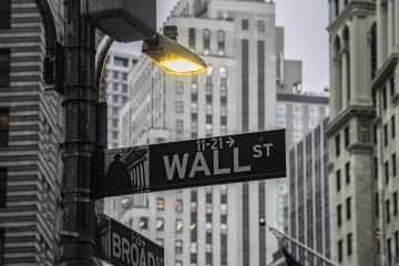 街灯に照らされた米ニューヨーク・ウォール街の標識＝10月（AP＝共同）