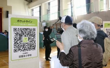 東北電力女川原発での重大事故を想定した防災訓練で、避難支援のスマートフォンアプリを使う住民ら＝29日午前、宮城県大崎市