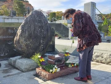 「原爆被害者の墓」に手を合わせる女性＝30日午後、東京都八王子市