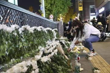 ソウル・梨泰院の事故現場近くで花を手向ける女性＝30日（ゲッティ＝共同）