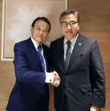 3日、ソウルで握手を交わす自民党の麻生副総裁（左）と韓国の朴振外相（韓国外務省提供、聯合＝共同）