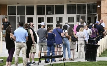 8月、米中間選挙に向けた予備選の投票所前に列をつくって並ぶ人たち＝米ワイオミング州シャイアン（共同）