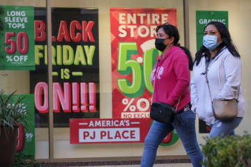 年末商戦シーズンに商店の前を歩く人＝2021年11月、米カリフォルニア州（AP＝共同）