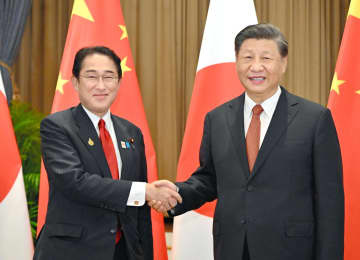 会談の冒頭、中国の習近平国家主席（右）と握手する岸田首相＝17日、バンコク（代表撮影・共同）