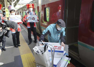 大阪での即日販売のため、水揚げされたズワイガニを特急列車に運び込む関係者＝19日、JR米子駅