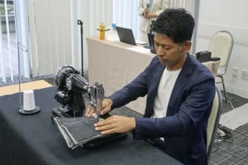 新商品のミシンで実演するアックスヤマザキの山崎一史社長＝10月、大阪市