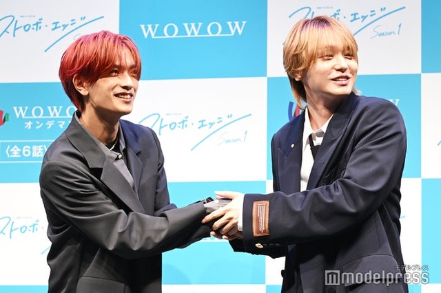 撮影初日になぜか高橋恭平の手をぎゅっと握ってしまったシーンを再現した伊野尾慧（C）モデルプレス