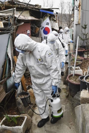 3日、ソウル市の低所得者層が住む地域を消毒する作業員ら（共同）