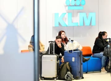 アムステルダム近郊のスキポール空港出発ラウンジで案内を待つKLMオランダ航空の乗客＝12日、スキポール（ロイター＝共同）